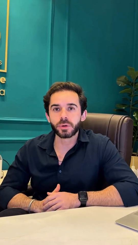 Thiago Benevides em seu consultório, com o monograma TB na parede